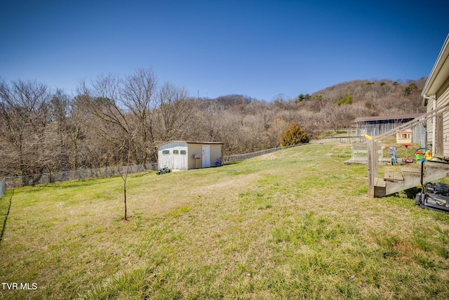 view of yard with a fenced backyard, an outdoor structure, and a shed