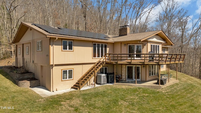 back of house with a yard, a patio, a chimney, and stairs