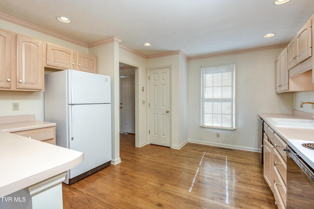 kitchen with light brown cabinets, a sink, light countertops, light wood-type flooring, and freestanding refrigerator