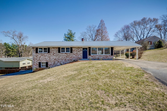 view of front of home with aphalt driveway, a front yard, an attached carport, and brick siding