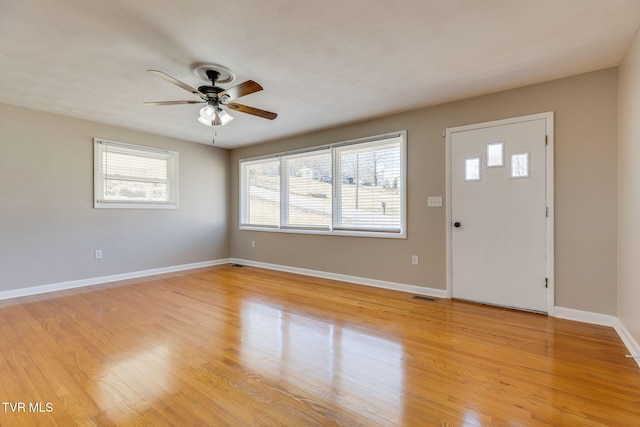 foyer entrance with a ceiling fan, baseboards, visible vents, and light wood finished floors