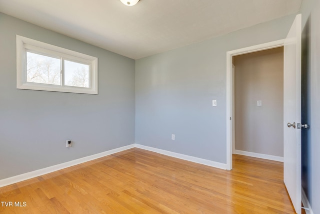 unfurnished room with light wood-type flooring and baseboards