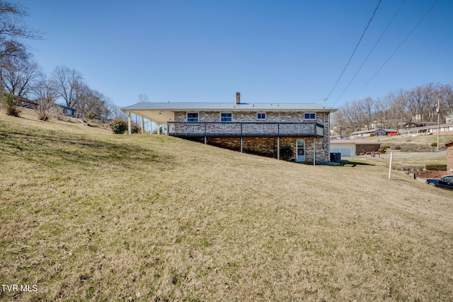 back of property featuring a yard, a chimney, and a wooden deck