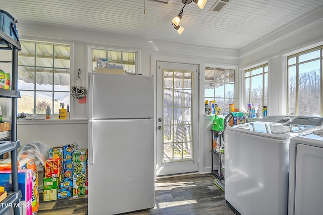 laundry room featuring laundry area, a healthy amount of sunlight, dark wood finished floors, and washer and dryer