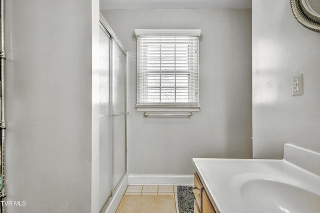 full bath with baseboards, vanity, a shower stall, and tile patterned floors