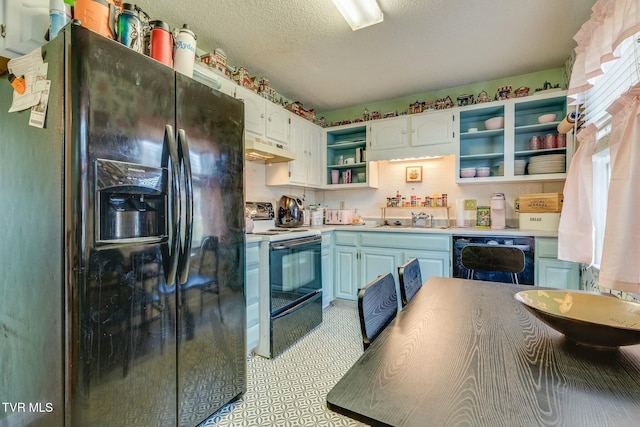 kitchen featuring open shelves, light countertops, a sink, under cabinet range hood, and black appliances