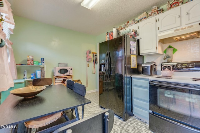 kitchen with white cabinets, electric stove, white microwave, under cabinet range hood, and black fridge