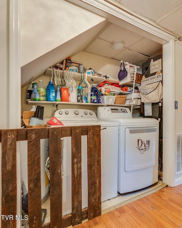 laundry room with washing machine and dryer, laundry area, and wood finished floors