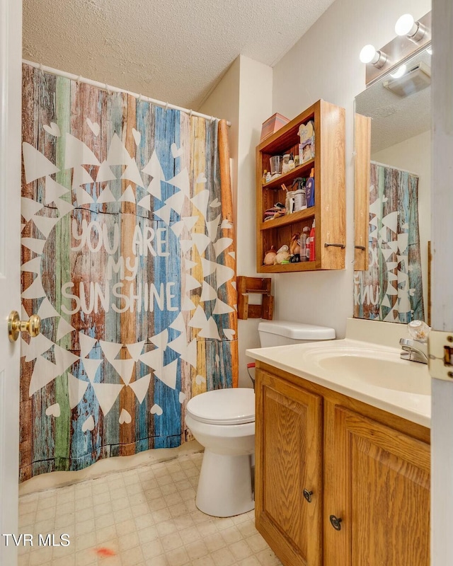 full bathroom featuring a shower with shower curtain, toilet, a textured ceiling, vanity, and tile patterned floors