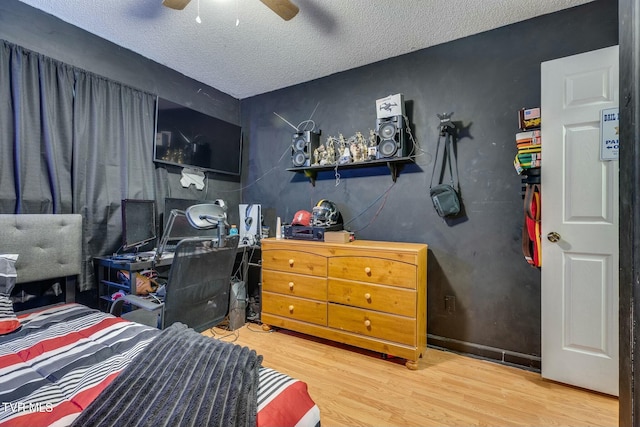 bedroom with ceiling fan, a textured ceiling, and wood finished floors