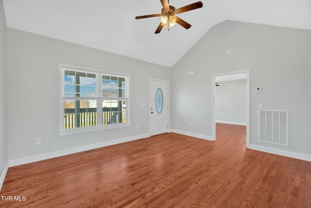 interior space featuring baseboards, visible vents, a ceiling fan, wood finished floors, and high vaulted ceiling