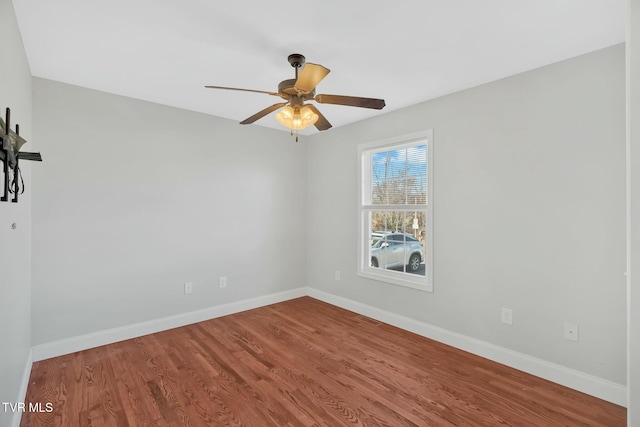 spare room featuring ceiling fan, baseboards, and wood finished floors