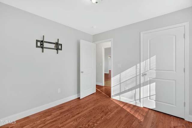 unfurnished bedroom featuring baseboards and wood finished floors