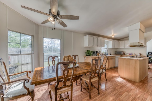 dining area featuring a ceiling fan, lofted ceiling, plenty of natural light, and light wood-style flooring