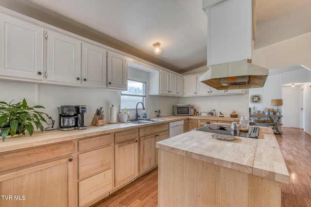 kitchen featuring island range hood, butcher block counters, a sink, dishwasher, and stainless steel microwave