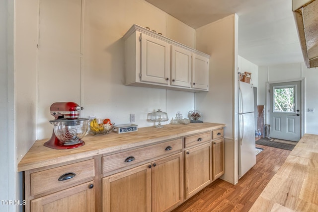 kitchen featuring light wood finished floors, wood counters, and freestanding refrigerator