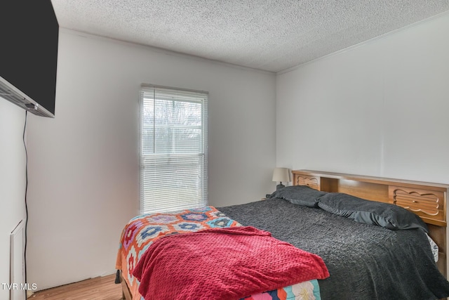 bedroom featuring a textured ceiling and wood finished floors