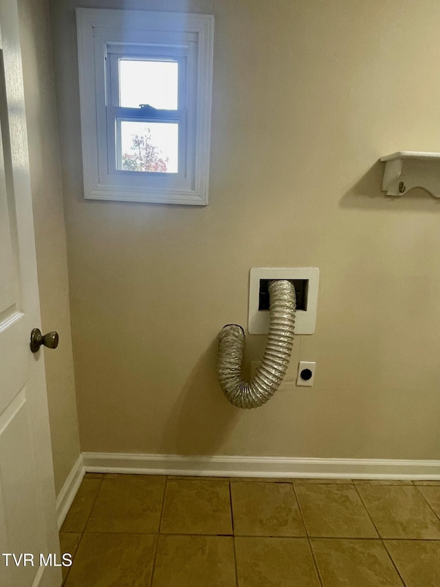 laundry room with electric dryer hookup, baseboards, laundry area, and tile patterned floors