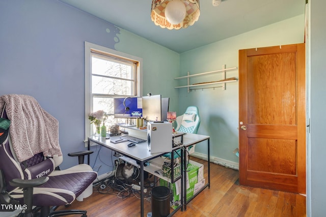 office space with vaulted ceiling, wood finished floors, and baseboards