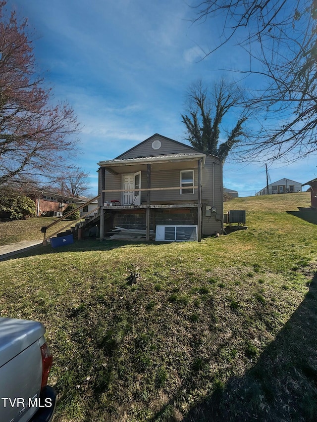 back of house featuring a lawn and cooling unit