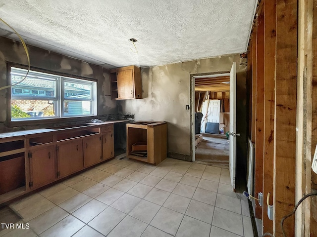 kitchen featuring open shelves, a textured ceiling, and light tile patterned floors