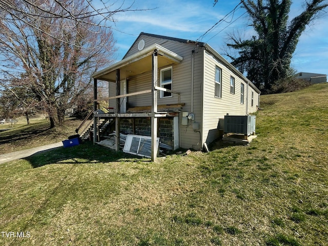 view of front facade featuring stairs, central AC unit, and a front lawn