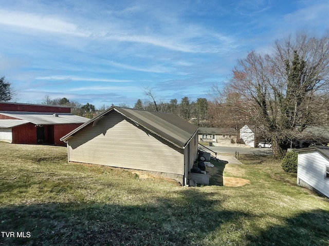 view of side of property with a pole building, a lawn, and an outdoor structure