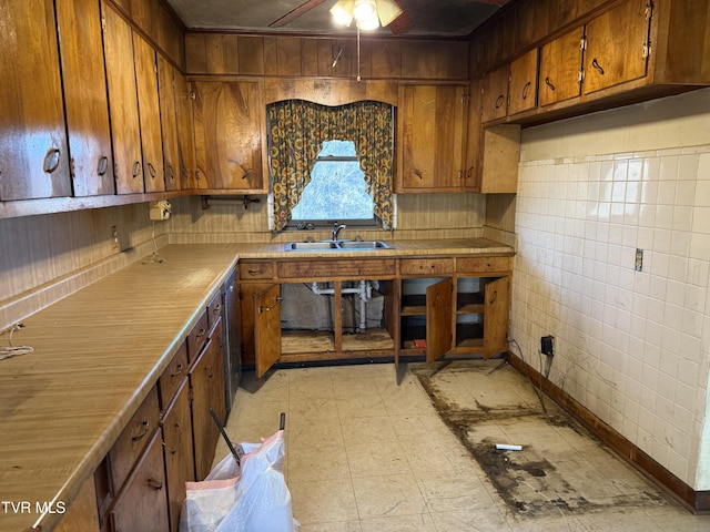 kitchen with brown cabinetry, a sink, and light countertops