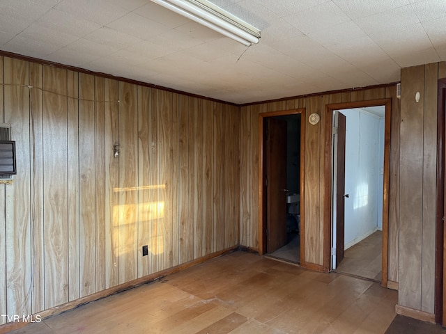 spare room featuring wood finished floors and wooden walls