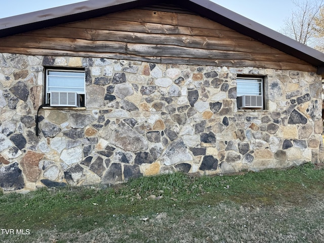 view of property exterior with stone siding and cooling unit