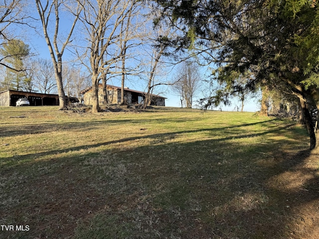 view of yard with a pole building, a carport, and an outdoor structure