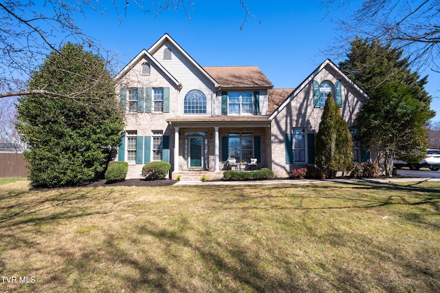 view of front of house featuring brick siding and a front yard