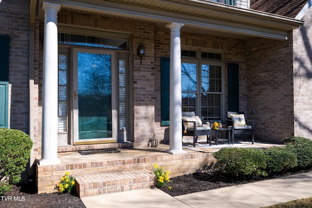 property entrance featuring a porch and brick siding