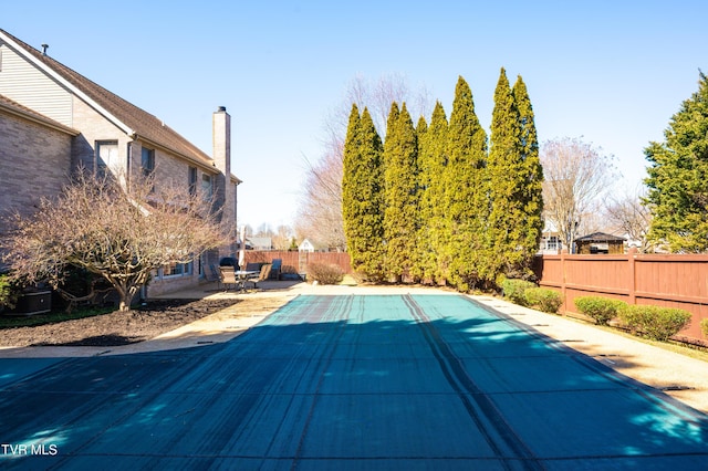 view of swimming pool featuring a patio, a fenced backyard, and a fenced in pool