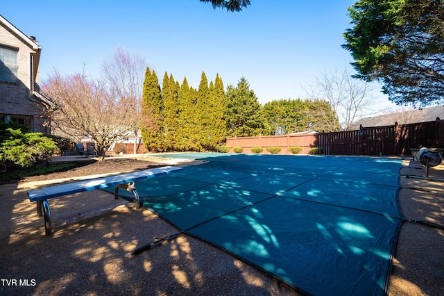 view of swimming pool with fence, a diving board, and a fenced in pool