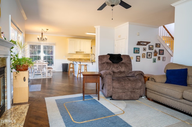 living area with ornamental molding, dark wood-style flooring, and a glass covered fireplace