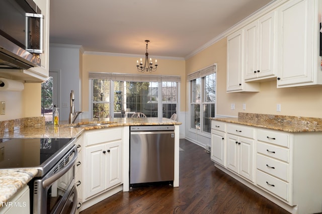 kitchen featuring dark wood-style flooring, crown molding, appliances with stainless steel finishes, white cabinets, and a sink