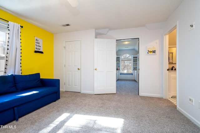 unfurnished living room with baseboards, visible vents, and carpet flooring