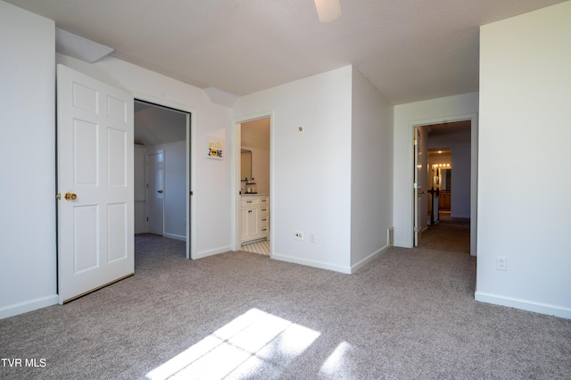 unfurnished bedroom featuring carpet floors, ensuite bath, and baseboards