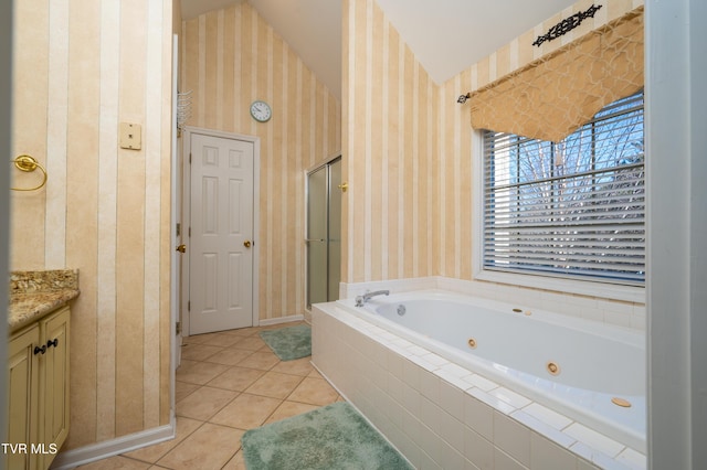 full bath featuring vaulted ceiling, vanity, a shower stall, a jetted tub, and tile patterned floors