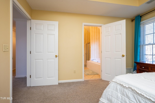 bedroom featuring baseboards, ensuite bath, visible vents, and carpet flooring