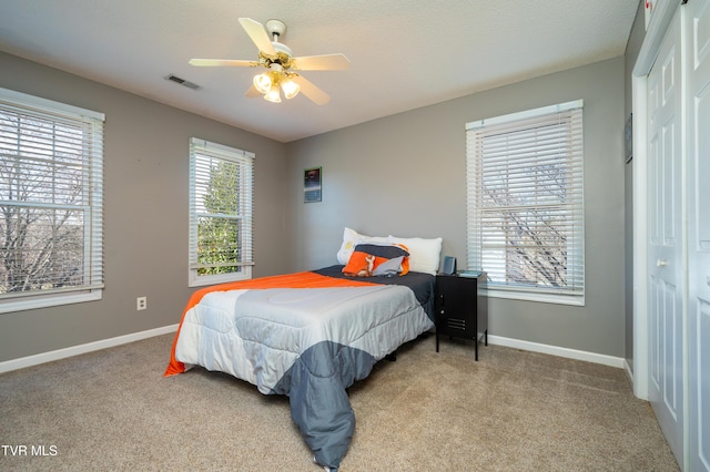 bedroom with multiple windows, visible vents, and carpet flooring