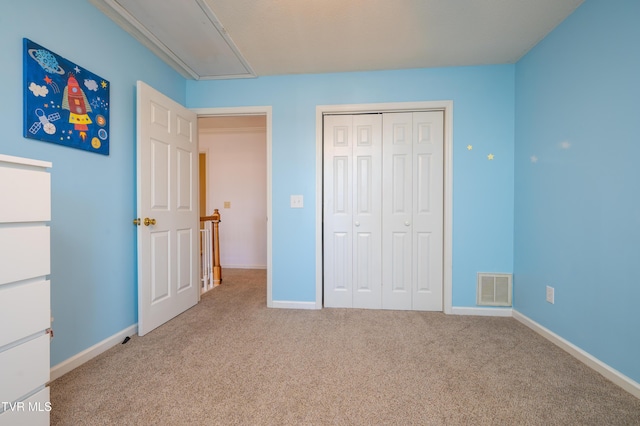 unfurnished bedroom with attic access, carpet flooring, visible vents, and baseboards