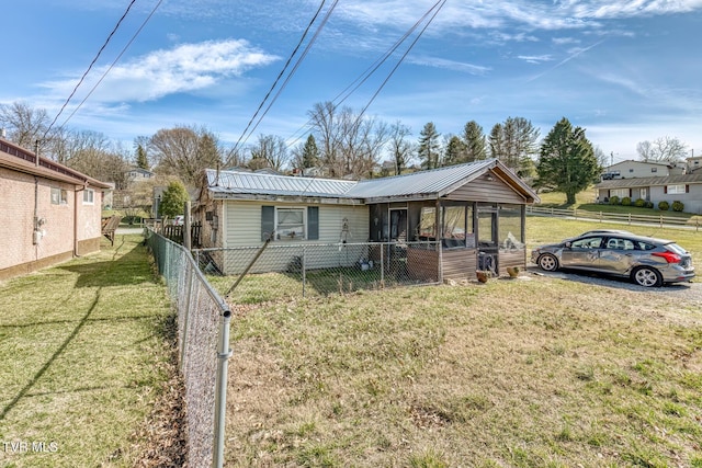 view of front facade featuring a front yard, metal roof, and fence