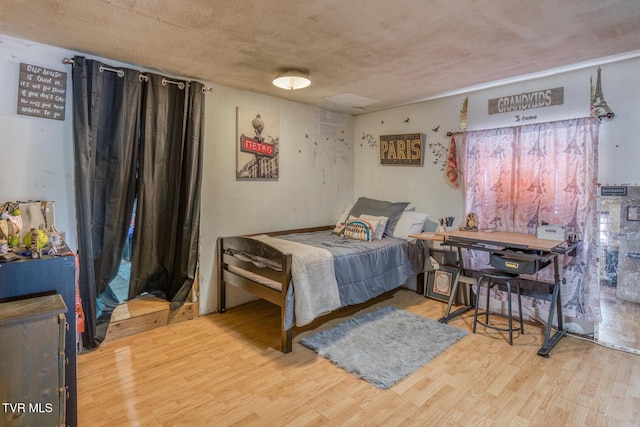 bedroom with a textured ceiling and wood finished floors