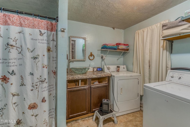 laundry room featuring a textured ceiling, washing machine and clothes dryer, and a sink