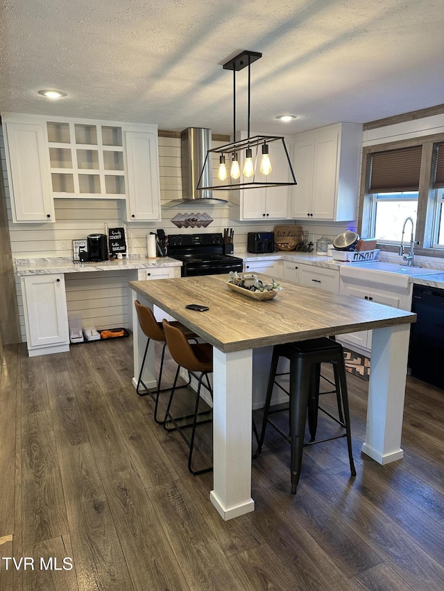 kitchen with open shelves, butcher block countertops, white cabinetry, wall chimney range hood, and black appliances