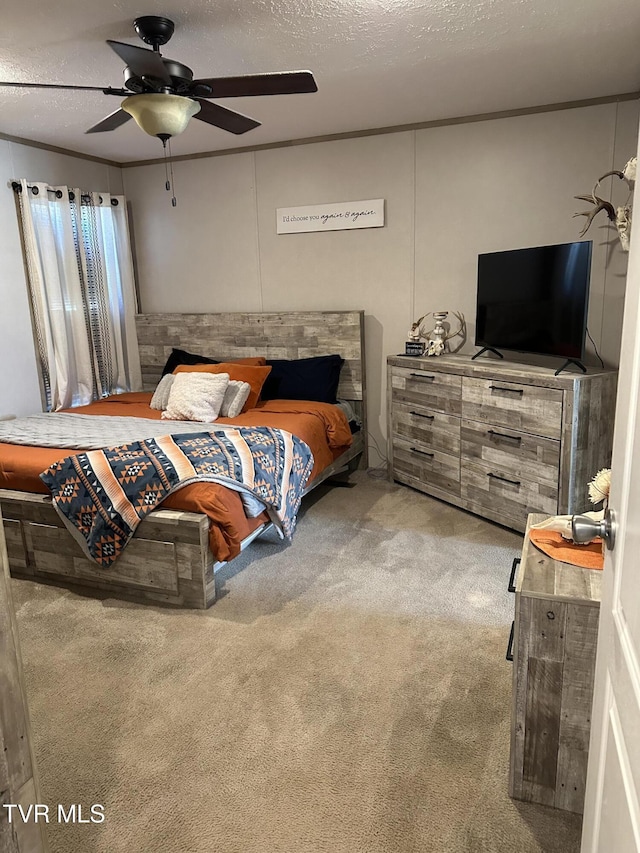 carpeted bedroom featuring a textured ceiling, a ceiling fan, and crown molding