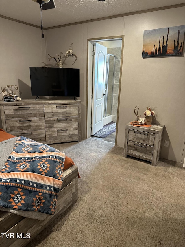 carpeted bedroom featuring ensuite bath, a textured ceiling, and crown molding