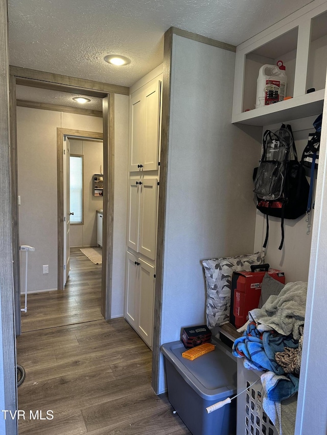 mudroom with a textured ceiling and wood finished floors